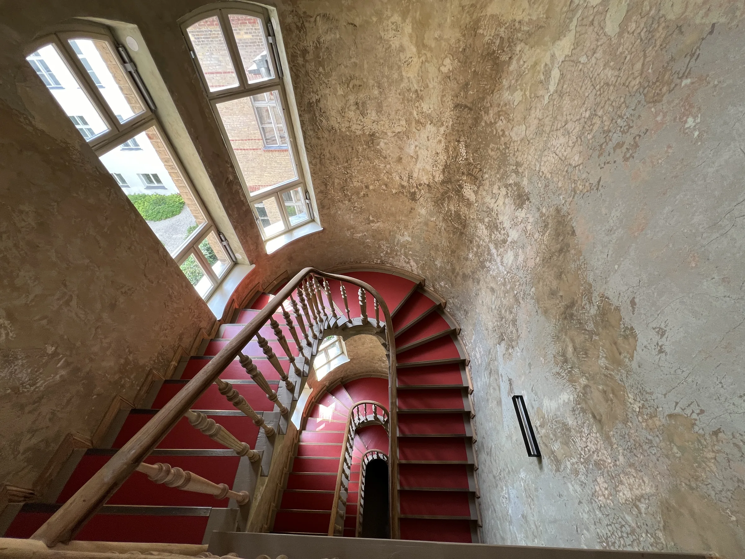 Restauriertes historisches Treppenhaus mit rotem Läufer