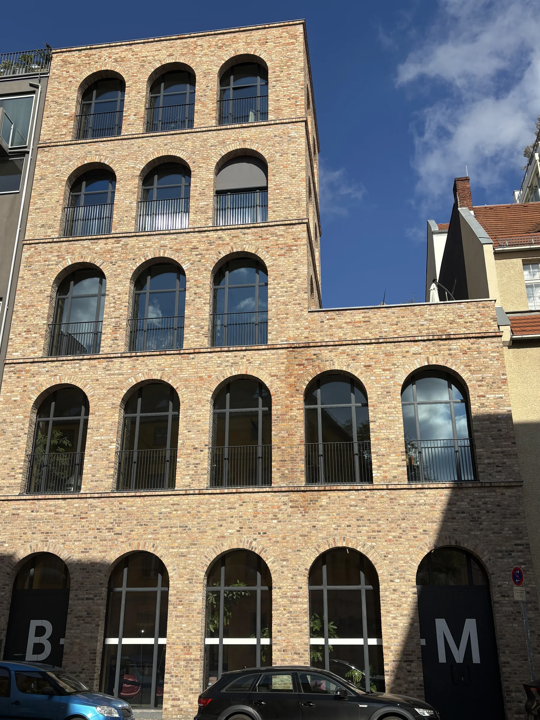Außenansicht des Gebäudes mit Backsteinfassade und Bogenfenstern